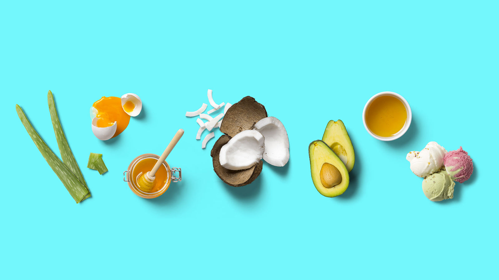 Flat lay of natural ingredients for DIY lubricants: aloe vera, coconut, honey, avocado and oil